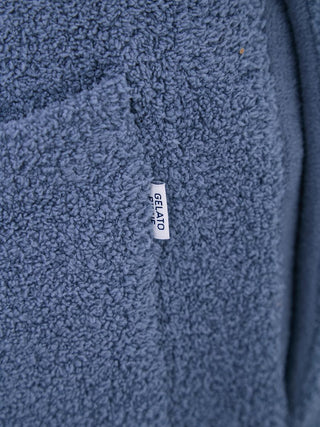 Close-up of Gelato Pique soft texture fabric with logo tag on pajama pants, showcasing luxurious comfort.