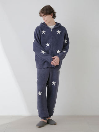 Model wearing Gelato Pique Powder Star Jacquard Lounge Pants and Hoodie in blue with white star pattern.