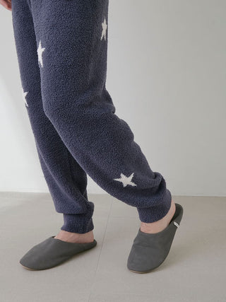 Legs wearing Powder Star Jacquard Lounge Pants with star pattern and gray slippers on a light background.
