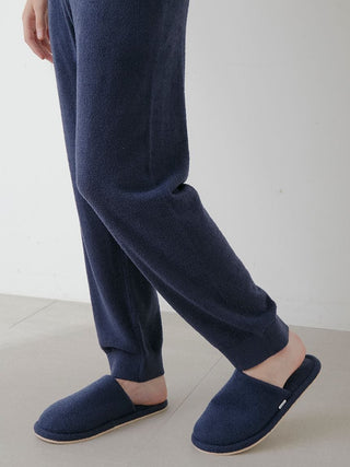 Person wearing Gelato Pique temperature-control smoothie lounge pants in navy, paired with matching slippers on a light floor.