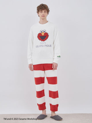 Model wearing Sesame Street men's jacquard pullover featuring Elmo and striped loungewear pants set.