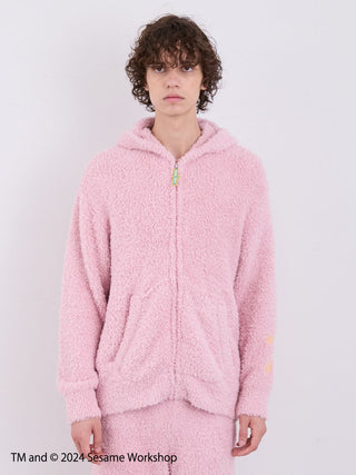 Model wearing pink Elmo hoodie and shorts loungewear set from Sesame Street's Gelato Pique collection, showcasing plush fabric.
