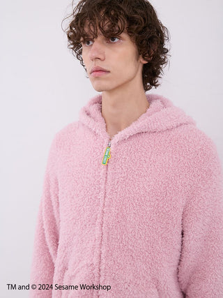 Model wearing Sesame Street men's Elmo pink fluffy hoodie loungewear set by Gelato Pique, showcasing cozy comfort.