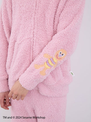 Close-up of pink Elmo loungewear set, featuring fluffy texture and Elmo design on the sleeve, by Gelato Pique.