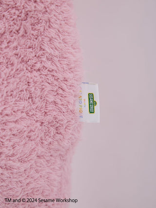 Close-up of fluffy pink fabric with Sesame Street label on Elmo Loungewear Set by Gelato Pique.