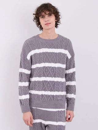 Man wearing Gelato Pique Mens Baby Moco Aran Border Pullover Sweater in grey with white stripes, showcasing cable knit design.