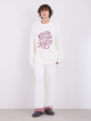 Man wearing a cozy white feather pullover sweater with festive text, paired with matching pants, showcasing lightweight winter wear.