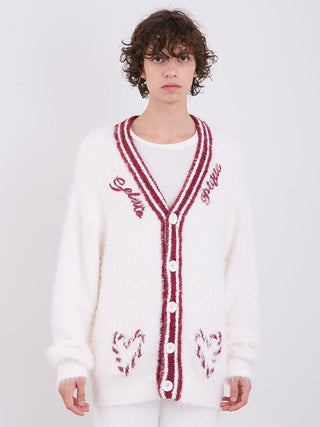 Model wearing a white feather-textured button-up cardigan with red stripes and heart designs, embodying cozy and festive elegance.