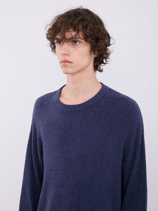 Model wearing men's navy blue ribbed sweater by Gelato Pique, featuring long sleeves and relaxed silhouette for cozy comfort.