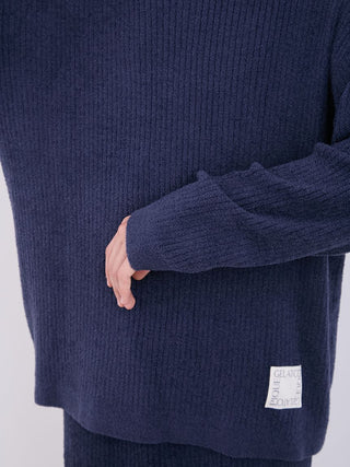 Close-up of a navy blue men's ribbed sweater with long sleeves by Gelato Pique, showcasing the soft knit texture and relaxed fit.