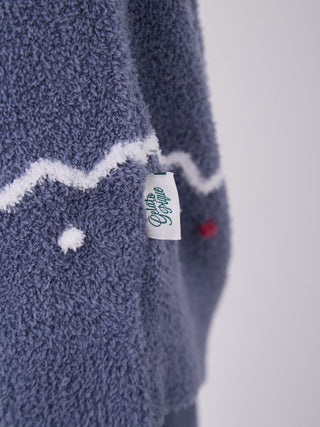 Close-up of Nordic Lounge Set with Gelato Pique tag, featuring a blue fluffy fabric and white patterned accents.