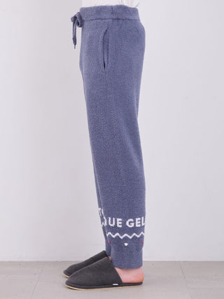 Side view of mens Nordic lounge pants with a jacquard design and fluffy fabric, paired with slippers.