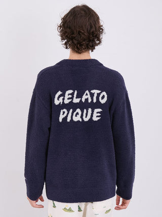 Back view of men's navy Gelato Pique cardigan with white logo text, worn by a person with curly hair, displaying cozy winter fashion.