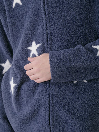 Close-up of a blue zip-up hoodie with white star jacquard pattern, showcasing cozy plush fabric texture.