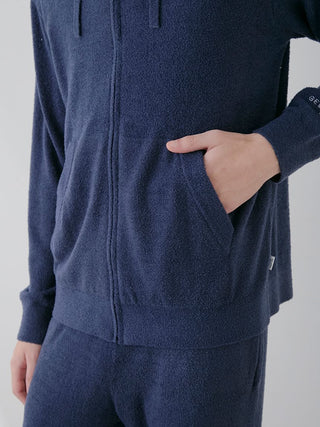 Person wearing a navy blue Temperature-Control Smoothie Zip-Up Hoodie with hand in pocket, showing texture of the soft fabric.