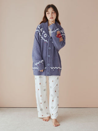 Model wearing unisex Nordic shawl collar cardigan with zigzag trims and teddy bear detailing, standing in cozy indoor setting.