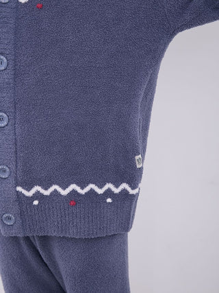 Close-up of unisex Nordic shawl collar cardigan with zigzag trim and navy plush fabric.