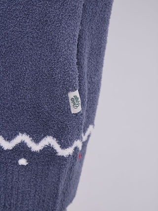 Close-up of Nordic shawl collar cardigan with zigzag trim detail in plush fabric.