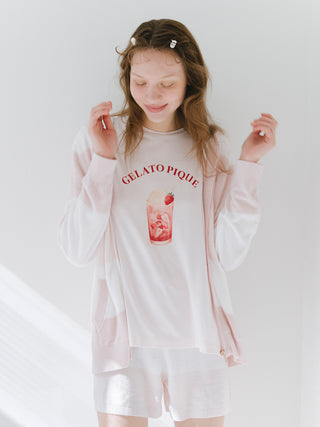 Woman wearing light pink loungewear with a gelato graphic, posing happily in bright setting.