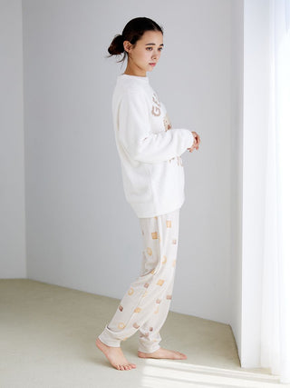 Person wearing Biscuit Pattern Waffle Pajama Pants, featuring playful biscuit motifs and cozy waffle-knit fabric, in a bright room.