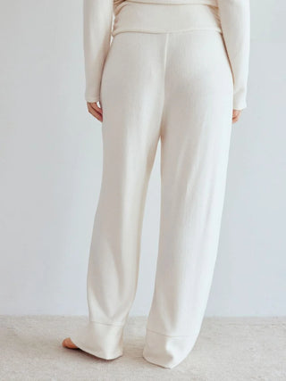 Person wearing Snow High-Waisted Lounge Pants in cream, showcasing wide-leg silhouette and soft fabric for comfort and style.