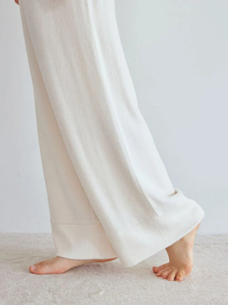 Woman wearing Snow High-Waisted Lounge Pants in soft fabric, showcasing wide-leg silhouette for chic loungewear style by Gelato Pique USA.