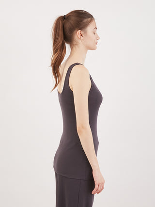 Side view of a woman wearing a black Water Absorption Tank Top by Gelato Pique USA, showcasing sleek design and comfortable fit.