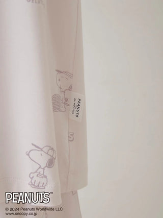 Close-up of PEANUTS Pajama Shirt with grey Snoopy print on white fabric.