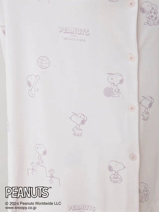 Close-up of PEANUTS printed pajama shirt with Snoopy sketches on a soft white background.