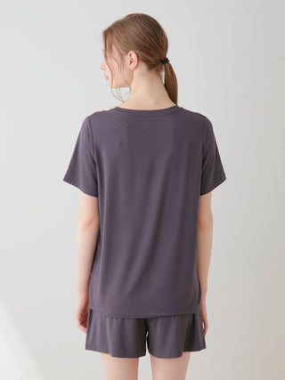 Back view of model wearing COOL Rayon Dessert Logo Relaxed Fit T-shirt, showcasing minimalist design and soft fabric.