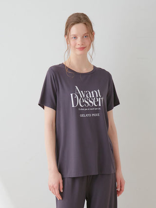 Woman wearing Avant Dessert Rayon Logo Relaxed Fit T-shirt in black, made of soft rayon for luxurious comfort and style.