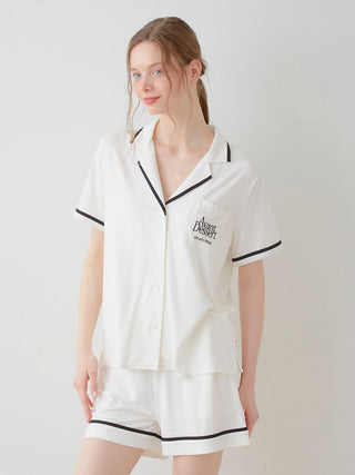 Woman wearing COOL Rayon Logo Button-Up Sleep Shirt in white with black trim, featuring Avant Dessert logo by Gelato Pique USA.