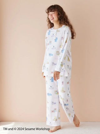 Woman wearing Sesame Street all-over print pullover and pants in soft rayon-blend fabric, featuring gelato pique's signature colors.