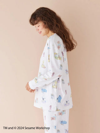 Woman wearing Sesame Street all-over print pullover made from soft rayon-blend fabric, showcasing Henley-neck design in signature colors.