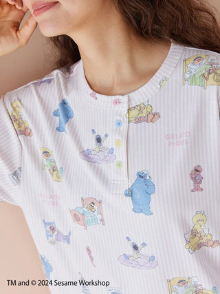 Cozy Sesame Street pullover with all-over character print and Henley neck design, made from a soft rayon-blend fabric.