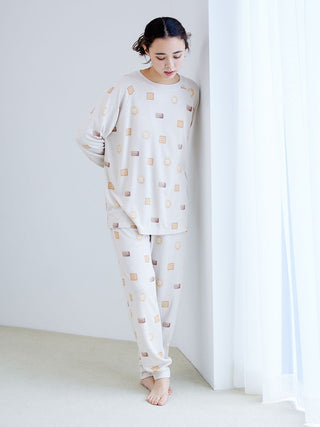 Woman wearing Biscuit Pattern Waffle Long Sleeve T-shirt and pants from Gelato Pique, featuring a cozy design with playful biscuit motif.