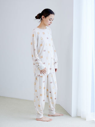 Woman wearing Biscuit Pattern Waffle Long Sleeve T-shirt with cozy waffle-knit texture, standing in a bright room, showcasing loungewear style.