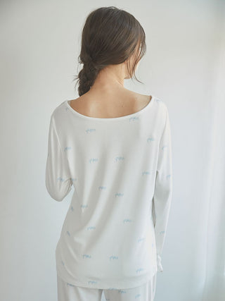 Back view of a woman wearing a white Motif 3-Pattern Long Sleeve T-Shirt, showcasing delicate motif patterns, ideal for lounging.