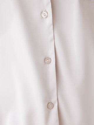 Close-up of buttons on lined satin sleep shirt with collar, showcasing luxurious chic design and elegant fabric texture.
