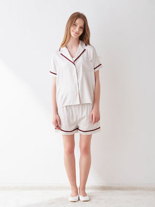 Model wearing a lined satin sleep shirt with collar, highlighting luxury comfort and chic design in a modern color scheme.