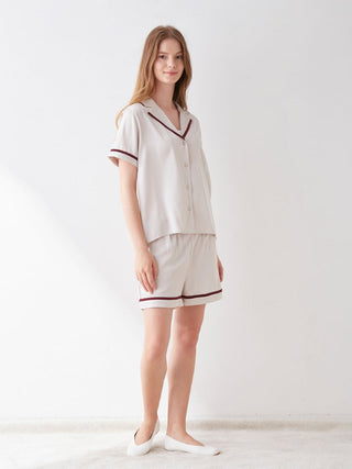 Woman wearing an elegant lined satin sleep shirt with chic collar, showcasing luxurious comfort and modern design, perfect for stylish slumber.