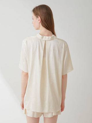 Back view of model wearing Gelato Pique Flower Satin Pajama Sleep Shirt with delicate floral print and luxurious satin fabric.