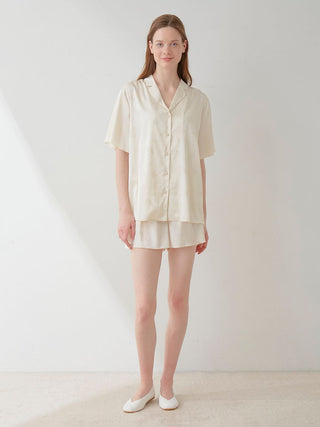 Woman wearing a flower satin pajama sleep shirt, elegantly designed with a delicate floral print and smooth satin fabric.