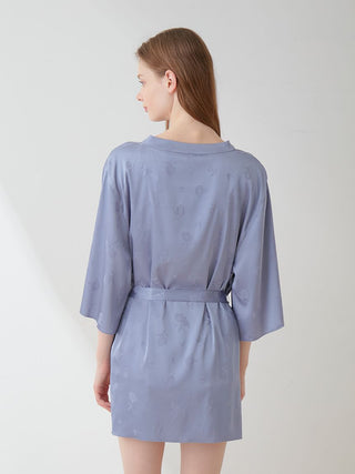 Back view of a woman wearing a flower long sleeve satin tie nightgown robe in lavender, showcasing elegant floral pattern design.