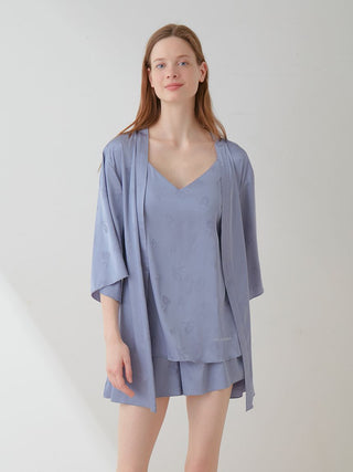 Woman wearing a floral satin tie nightgown robe with long sleeves, showcasing elegant and luxurious loungewear style.