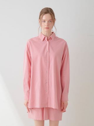 Woman wearing a pink Resort Woven Long Sleeve Oversized Shirt with matching shorts, showcasing relaxed elegance and modern style.