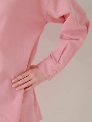 Close-up of a pink long sleeve oversized shirt with buttoned cuff, showcasing the woven fabric and relaxed fit.