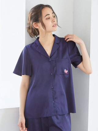 Woman wearing Strawberry Embroidered Satin Sleep Shirt in navy, showcasing button-up design and soft luxurious fabric.