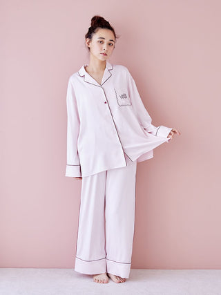 Woman wearing Piping Satin Long Sleeve Pajama Shirt with elegant piping details, highlighting luxury loungewear style against pink background.