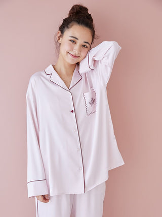Woman wearing pink piping satin long sleeve pajama shirt with elegant piping detail.